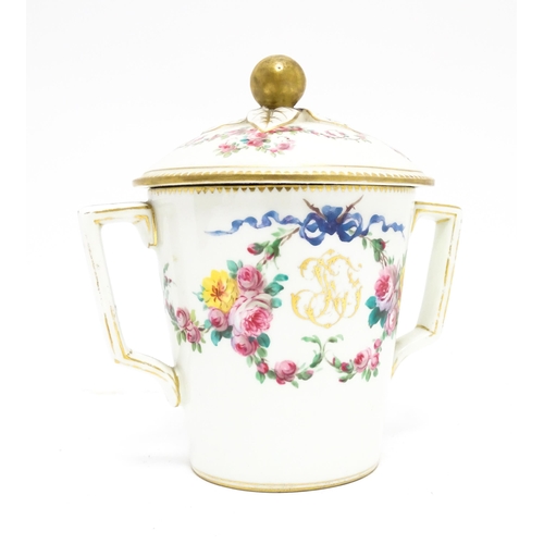 84 - A Sevres twin handled pot and cover decorated with floral garlands and bow detail, with gilt monogra... 