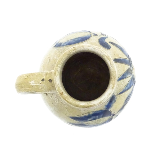 97 - A German Westerwald stoneware jug with single handle, the body with blue painted detail and initials... 