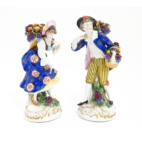 190 - A pair of Chelsea style harvest / fruit seller figures modelled as a man and a woman with baskets of... 