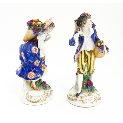 190 - A pair of Chelsea style harvest / fruit seller figures modelled as a man and a woman with baskets of... 