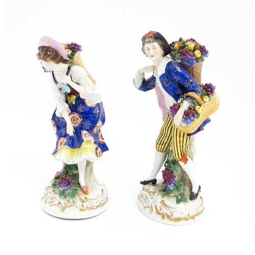 190 - A pair of Chelsea style harvest / fruit seller figures modelled as a man and a woman with baskets of... 