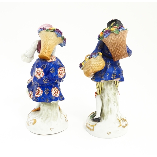 190 - A pair of Chelsea style harvest / fruit seller figures modelled as a man and a woman with baskets of... 