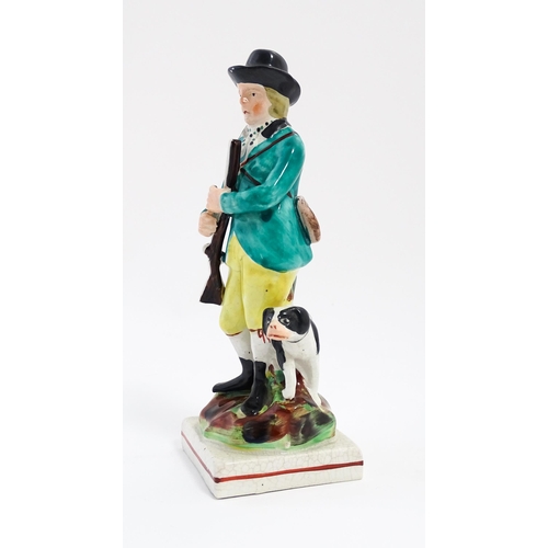 192 - A Staffordshire pearlware model of a huntsman and gun dog / hound on a squared base. Approx. 7 1/2