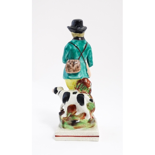 192 - A Staffordshire pearlware model of a huntsman and gun dog / hound on a squared base. Approx. 7 1/2