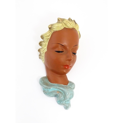 193 - An Art Deco Goldscheider wall mask modelled as a female face with painted features and blonde hair. ... 