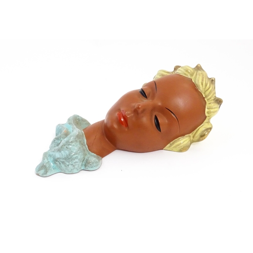 193 - An Art Deco Goldscheider wall mask modelled as a female face with painted features and blonde hair. ... 