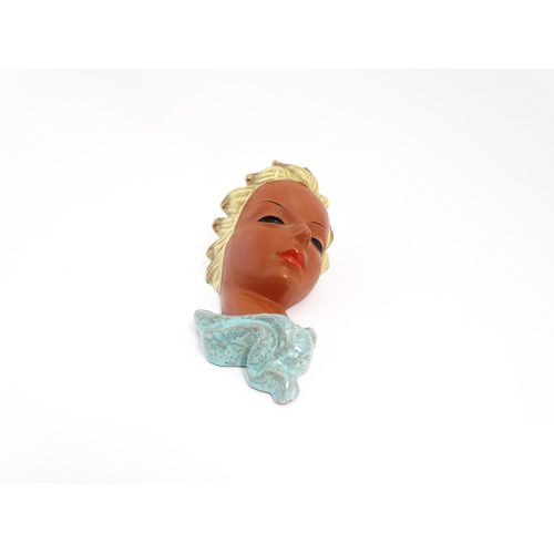 193 - An Art Deco Goldscheider wall mask modelled as a female face with painted features and blonde hair. ... 