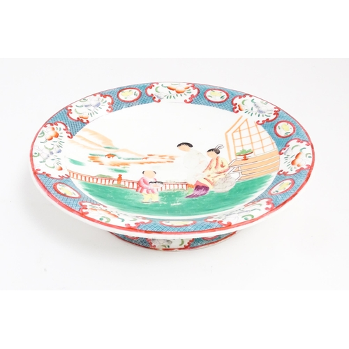 199 - A Minton style footed comport / tazza with chinoiserie decoration depicting three figures on a terra... 