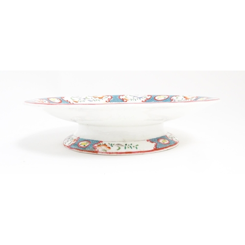 199 - A Minton style footed comport / tazza with chinoiserie decoration depicting three figures on a terra... 