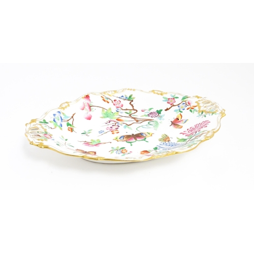 201 - A dish of shaped form with hand painted floral, foliate and butterfly decoration, with gilt highligh... 