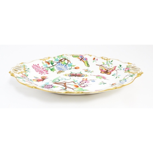 201 - A dish of shaped form with hand painted floral, foliate and butterfly decoration, with gilt highligh... 