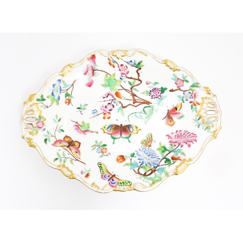 201 - A dish of shaped form with hand painted floral, foliate and butterfly decoration, with gilt highligh... 