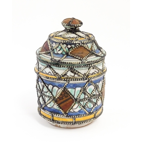 213 - A Persian pot and cover with banded decoration and applied geometric detail. Approx. 6 1/2