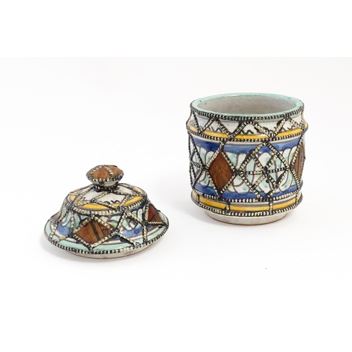 213 - A Persian pot and cover with banded decoration and applied geometric detail. Approx. 6 1/2