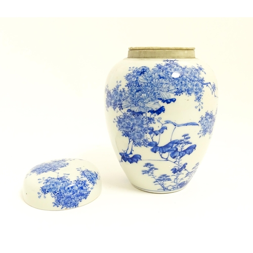 4 - A Japanese blue and white ginger jar / tea caddy decorated with flowers and foliage. Approx. 7 3/4