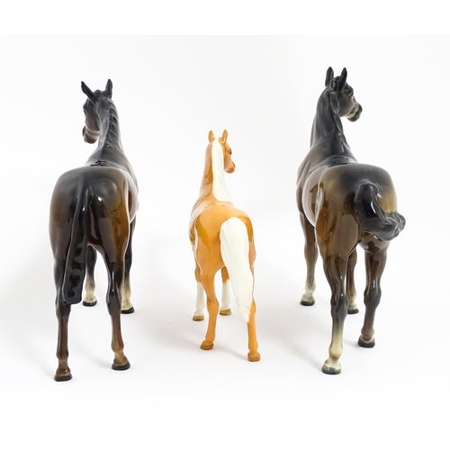 121 - Three Beswick models of horses comprising a brown horse with swish tail, no. 1182, a brown imperial,... 