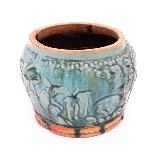 25 - A Shiwan style vase with a blue / green glaze and twin mask handles, the body decorated in relief wi... 