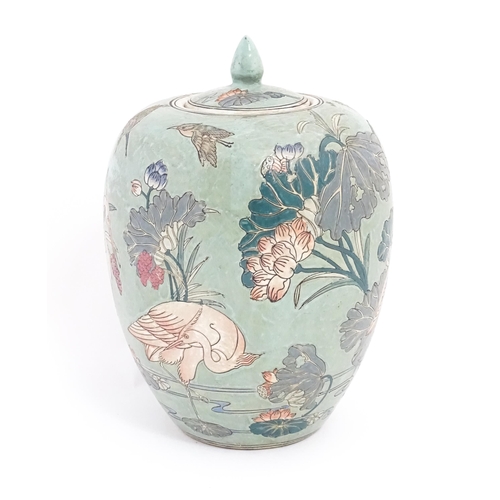 7 - A Chinese ginger jar with celadon style glaze decorated with crane birds, flowers, lily pads, etc. C... 