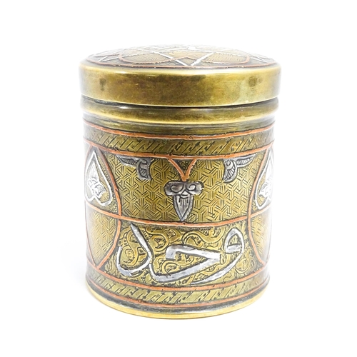 1070 - An early 20thC Middle Eastern brass pot and cover with engraved detail and inlaid white metal and co... 