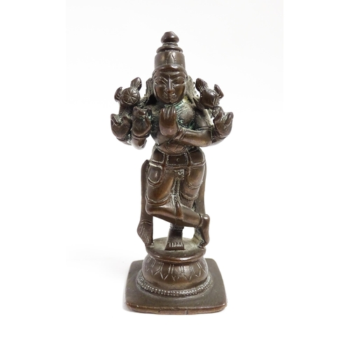 1076 - A small Indian bronze model of the deity Vishnu holding a chakra and sankha. Approx. 3