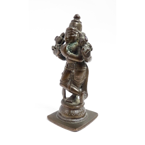 1076 - A small Indian bronze model of the deity Vishnu holding a chakra and sankha. Approx. 3