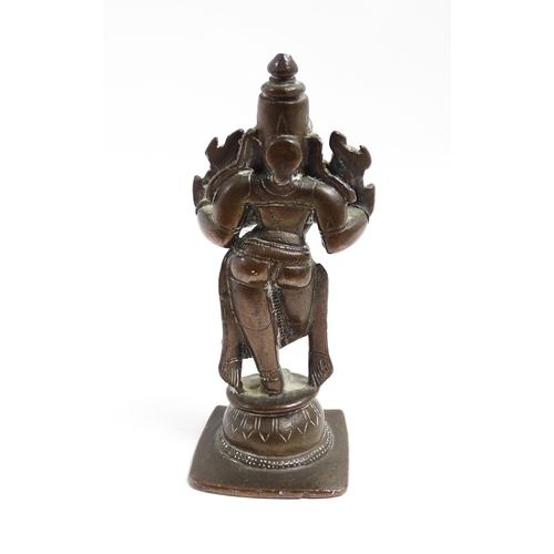 1076 - A small Indian bronze model of the deity Vishnu holding a chakra and sankha. Approx. 3