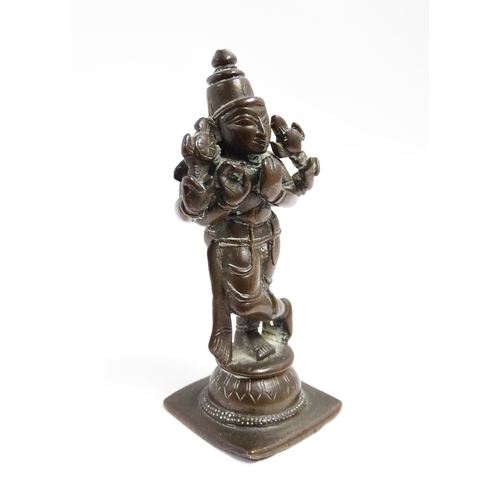 1076 - A small Indian bronze model of the deity Vishnu holding a chakra and sankha. Approx. 3