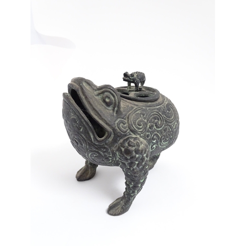 1078 - A Chinese cast censer modelled as a three legged toad with scrolling decoration, the pierced lid wit... 