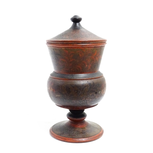 1089 - A Scandinavian folk art pedestal pot and cover with turned and lacquered foliate decoration. Approx.... 