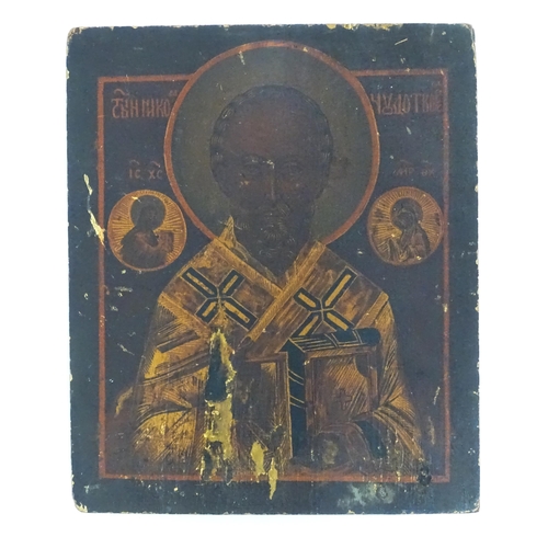 1095 - A 19thC Russian tempera on card laid on wooden panel icon depicting St. Nicholas of Myra flanked by ... 