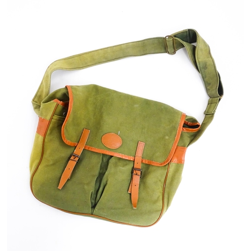 1109 - A canvas and leather fishing game bag, with large rear pocket, two further pockets to the front and ... 