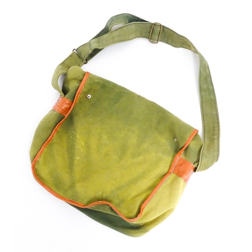 1109 - A canvas and leather fishing game bag, with large rear pocket, two further pockets to the front and ... 