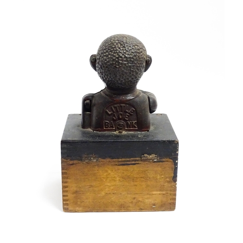 1113 - A cast iron novelty money box / piggy bank titled 'Little Joe Bank'. Mounted on a wooden box. Approx... 