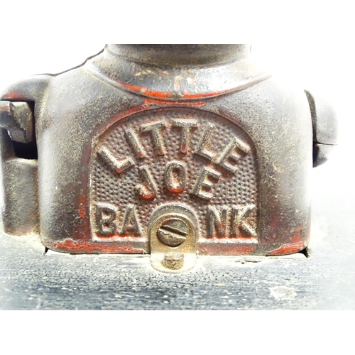 1113 - A cast iron novelty money box / piggy bank titled 'Little Joe Bank'. Mounted on a wooden box. Approx... 