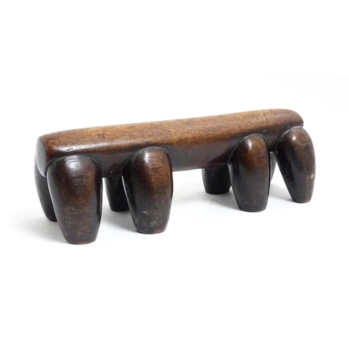 1122 - Ethnographic / Native / Tribal: A tribal carved wooden head rest with eight supports. Approx. 4 1/4