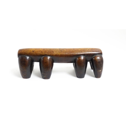 1122 - Ethnographic / Native / Tribal: A tribal carved wooden head rest with eight supports. Approx. 4 1/4