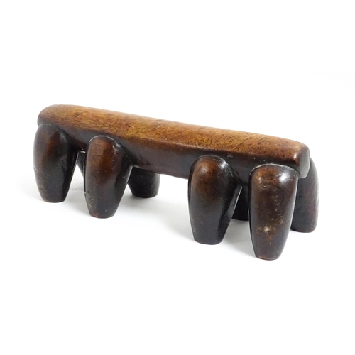 1122 - Ethnographic / Native / Tribal: A tribal carved wooden head rest with eight supports. Approx. 4 1/4