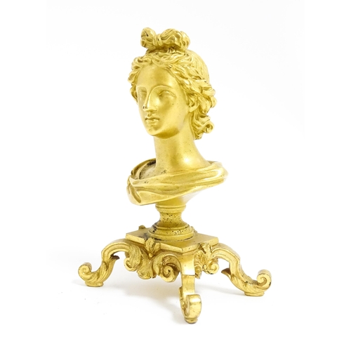 1031 - A small 19thC gilt bronze bust of a lady with a ribbon in her hair, on a scrolled gilt base. Approx.... 