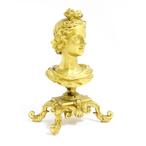 1031 - A small 19thC gilt bronze bust of a lady with a ribbon in her hair, on a scrolled gilt base. Approx.... 