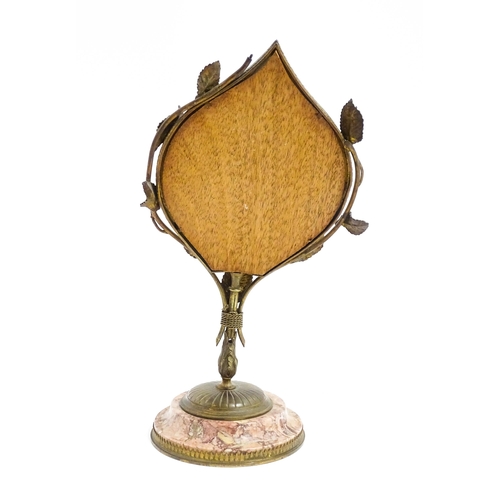 1034 - An Art Nouveau pedestal desk mirror of leaf form, with gilt metal left detail, raised on a circular ... 