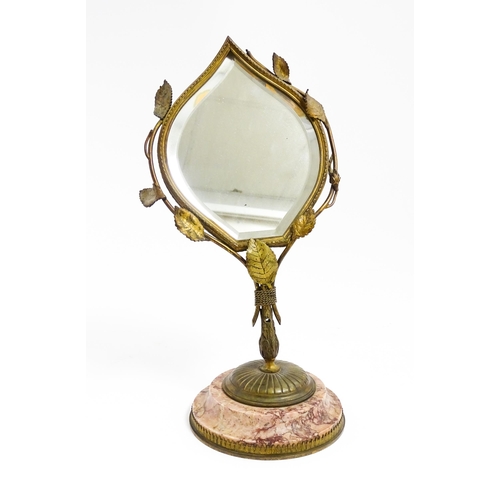 1034 - An Art Nouveau pedestal desk mirror of leaf form, with gilt metal left detail, raised on a circular ... 