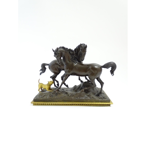 1037 - A 20thC cast bronze sculpture depicting two horses with a gilt dog barking at them, on a naturalisti... 