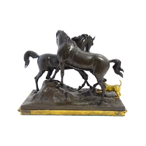 1037 - A 20thC cast bronze sculpture depicting two horses with a gilt dog barking at them, on a naturalisti... 