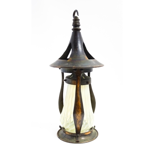 1055 - An Arts & Crafts copper pendant light frame of lantern form, the copper supports with hammered decor... 