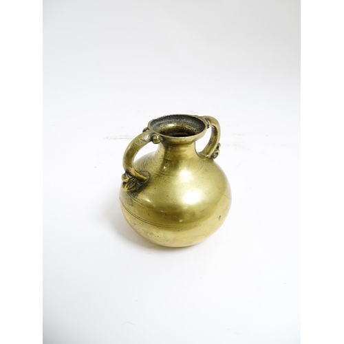 1056 - An Asian brass twin handled vase with banded detail. Approx. 3 1/2