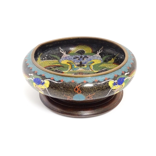 1058 - A Chinese cloisonne dish the black ground with dragon and flaming pearl decoration. Character marks ... 