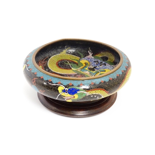 1058 - A Chinese cloisonne dish the black ground with dragon and flaming pearl decoration. Character marks ... 