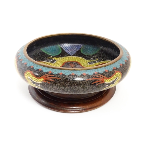 1058 - A Chinese cloisonne dish the black ground with dragon and flaming pearl decoration. Character marks ... 