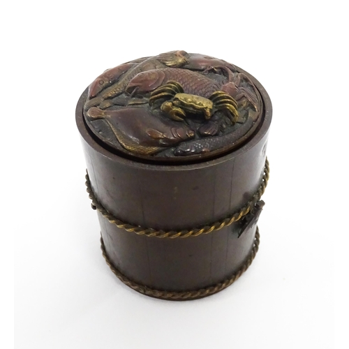 1060 - A Japanese bronze novelty inkwell of cylindrical form, the lid with fish and crab detail, the body w... 