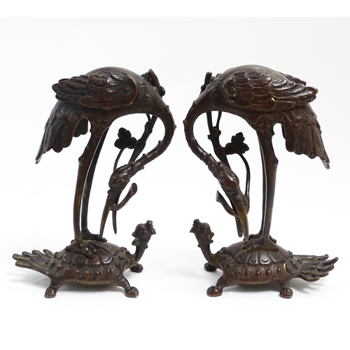 1062 - A pair of Japanese cast sculptures modelled as a stylised crane standing on a tortoise. Approx. 7 1/... 